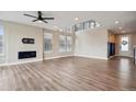 Spacious living room featuring hardwood floors, a fireplace, and a wall of windows for lots of natural light at 1660 Candleflower Dr, Castle Pines, CO 80108