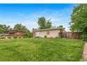 The property features a spacious, well-maintained backyard with lush grass and mature trees, offering privacy at 8051 S Kendall Blvd, Littleton, CO 80128