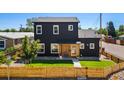 Two-story modern home with black siding, a well-maintained lawn, and a wooden fence at 550 S Raleigh St, Denver, CO 80219