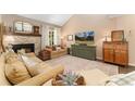 Cozy living room features a stone fireplace, neutral tones, plush seating, and large TV at 938 W Peakview Cir, Littleton, CO 80120
