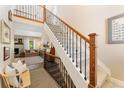 Inviting home showcasing a staircase with wooden railing and iron balusters leading to a spacious living area at 938 W Peakview Cir, Littleton, CO 80120