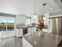 Modern kitchen with stainless appliances, gray countertops, pendant lights, and sliding glass door to the deck at 10536 Garrison St, Westminster, CO 80021