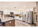Spacious kitchen featuring stainless steel appliances, granite countertops, and modern white cabinetry at 6900 S Clermont St, Centennial, CO 80122