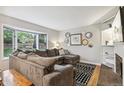 Cozy living room featuring a large bay window, a spacious sectional sofa, and stylish accent pieces at 6712 S Leyden Ct, Centennial, CO 80112