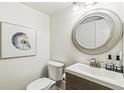 Stylish powder room with a modern vanity, a decorative mirror, and elegant wall art at 6712 S Leyden Ct, Centennial, CO 80112