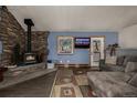 Comfortable living room featuring a stone fireplace, hardwood floors and a cozy sofa at 54 Zaza Ln, Evergreen, CO 80439