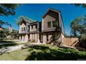 Angle view of a modern three-story townhome featuring a landscaped front yard and unique wooden details at 2530 Chase, Edgewater, CO 80215