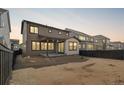 Exterior view of a two-story home featuring an outdoor patio and a fenced backyard at 8893 Springsong Ln, Littleton, CO 80125