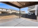 Outdoor patio with backyard and tall, dark fencing around the perimeter of the yard at 8893 Springsong Ln, Littleton, CO 80125