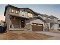 Charming two-story home with a two-car garage, stone accents, and a covered front porch at 8893 Springsong Ln, Littleton, CO 80125