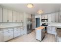 Modern kitchen featuring stainless steel appliances, granite countertops, grey cabinets, and a kitchen island at 1785 S Zuni St, Denver, CO 80223