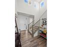 Bright foyer with hardwood floors, staircase, and modern chandelier, creating a grand entry at 24784 E Tennessee Pl, Aurora, CO 80018