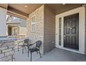 Inviting front porch with seating and decorative stone accents, offering a cozy entrance at 24784 E Tennessee Pl, Aurora, CO 80018