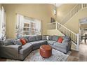 Comfortable living room with a large sectional sofa, ottoman, and staircase at 3928 Miners Candle Dr, Castle Rock, CO 80109