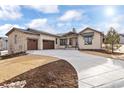 Inviting home exterior with stone accents, covered entryway, three car garage, and curved driveway at 8015 Parnassus Pl, Castle Rock, CO 80108