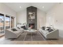 Bright living room with stone fireplace, vaulted ceiling, and sliding glass doors to the outside at 8015 Parnassus Pl, Castle Rock, CO 80108
