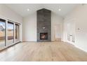 Light-filled living room with a stone fireplace, vaulted ceiling, and access to the backyard at 8015 Parnassus Pl, Castle Rock, CO 80108