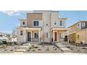 Two-story townhomes with light brick and neutral siding, covered porches, and landscaping at 24501 E 41St Ave, Aurora, CO 80019