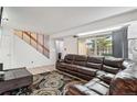 Living room showcasing a sectional sofa, stairs, and sliding door access at 7995 E Mississippi Ave # J1, Denver, CO 80247