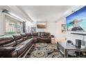 Bright living room featuring a sectional sofa, large TV, and access to backyard at 7995 E Mississippi Ave # J1, Denver, CO 80247