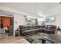 Open living area with leather sectional sofa and access to entryway at 7995 E Mississippi Ave # J1, Denver, CO 80247