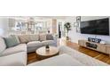 Bright and open living room with hardwood floors, stylish furniture, and an open concept design leading to the kitchen at 2674 S Krameria St, Denver, CO 80222