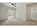 Bright living room with plush carpet, balcony access, and ceiling fan at 1881 S Dunkirk St # 106, Aurora, CO 80017