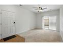 Neutral living room with door, balcony access, and ceiling fan at 1881 S Dunkirk St # 106, Aurora, CO 80017