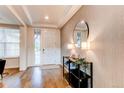 Elegant entryway features wood floors, textured wallpaper, and stylish decor for a welcoming ambiance at 8107 Arapahoe Peak St, Littleton, CO 80125