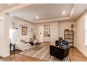 Bright living room includes modern furniture, white trim, tray ceiling, and an adjacent butler's pantry at 8107 Arapahoe Peak St, Littleton, CO 80125