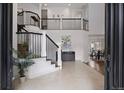 Grand foyer with high ceilings, staircase with iron railings, and an open layout to the dining and living spaces at 510 Castle Pines Dr, Castle Rock, CO 80108