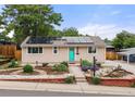 Charming home with solar panels, a well-kept yard, and a pop of color on the front door at 741 Cortez St, Denver, CO 80221