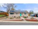 Charming home boasts a solar roof, bright turquoise front door, and beautiful brick-lined landscaping at 741 Cortez St, Denver, CO 80221