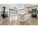 Open kitchen with an island, stainless appliances, and hardwood floors to the living area at 741 Cortez St, Denver, CO 80221