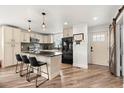 Open kitchen with an island, modern appliances, stylish pendant lights, and updated flooring at 741 Cortez St, Denver, CO 80221