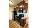 Well-lit kitchen with stainless steel appliances, gas range, granite counters, and wood cabinets at 10702 E Exposition Ave # 101, Aurora, CO 80012