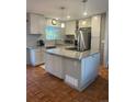 Well-lit kitchen featuring a granite countertop island, stainless steel appliances, and hardwood floors at 3097 W 134Th Way, Broomfield, CO 80020