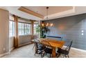 Elegant dining room with a wood table, stylish light fixture, and a large window at 6488 S Kewaunee Way, Aurora, CO 80016
