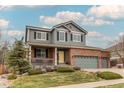 Charming two-story home with a well-manicured lawn, a yellow front door, and a three-car garage at 6488 S Kewaunee Way, Aurora, CO 80016