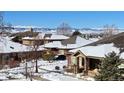 Charming neighborhood homes covered in snow, with mountain views in the background, under a clear blue sky at 8571 Gold Peak Dr # C, Highlands Ranch, CO 80130