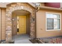 Charming front entrance with a stone archway, painted yellow door, and clearly visible unit number at 8571 Gold Peak Dr # C, Highlands Ranch, CO 80130