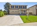 Front exterior of two-story home with a two car garage, manicured lawn, and inviting front porch at 16893 Trail View Cir, Parker, CO 80134