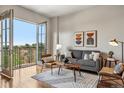 Bright living room featuring hardwood floors, modern decor, and balcony access with a view at 410 Acoma St # 518, Denver, CO 80204