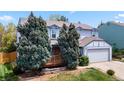 Two-story home with light blue paint, a two-car garage, and a charming front porch at 15909 E Ford Pl, Aurora, CO 80017