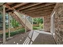Covered back patio with stone facade, view of stairs, yard and fence at 10646 Amesbury Way, Highlands Ranch, CO 80126