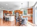 Bright kitchen featuring warm wood cabinetry, an island, stainless appliances, and a breakfast table at 10646 Amesbury Way, Highlands Ranch, CO 80126