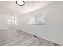 Inviting living room with large windows, new gray flooring, and fresh white paint for a bright modern look at 1537 Xenia St, Denver, CO 80220