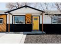 Charming single-story home boasting a vibrant yellow door and modern design elements at 5261 Chandler Way, Denver, CO 80239