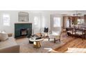 Open concept living space with a green tile fireplace and hardwood floors at 2809 Forest St, Denver, CO 80207