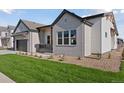 Charming home featuring gray brick, a two-car garage, and pristine landscaping at 1425 Burt Ave, Berthoud, CO 80513